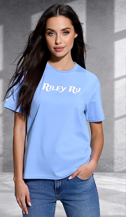 Woman wearing a blue t-shirt with 'Riley Ru' text against a gray background