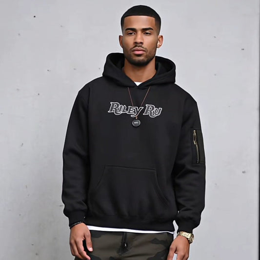 Man wearing a black hoodie with text and camouflage pants against a gray background