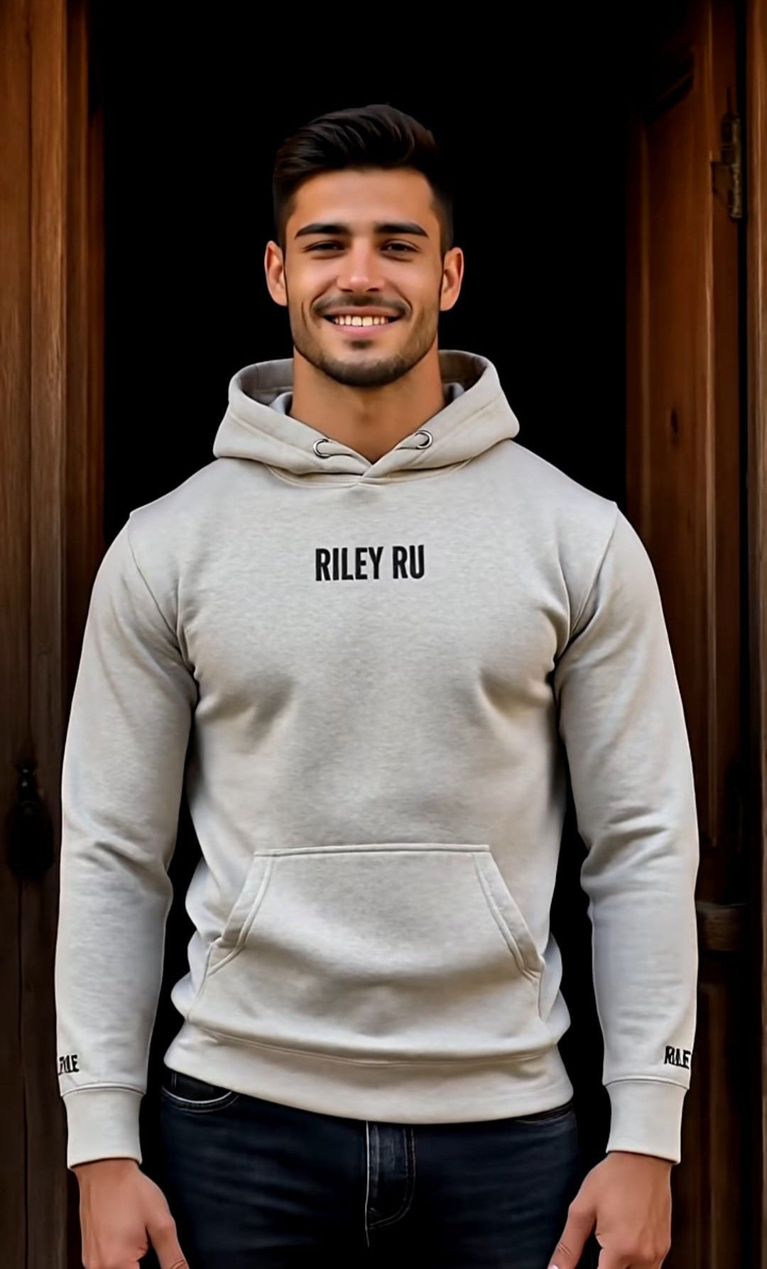 Man wearing a gray hoodie with 'RILEY RU' branding against a dark background