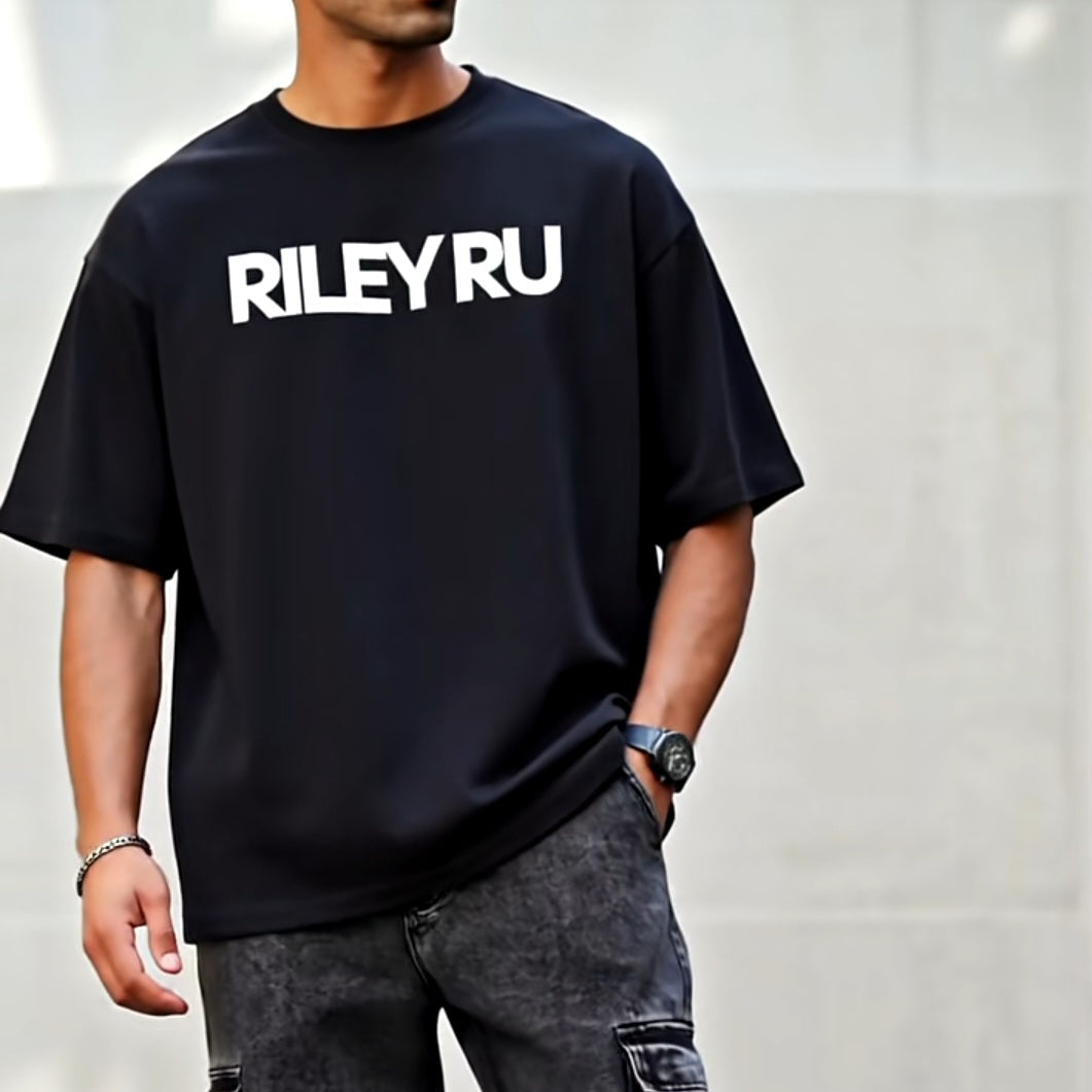 Person wearing a black t-shirt with 'RILEYRU' text and dark jeans against a plain background