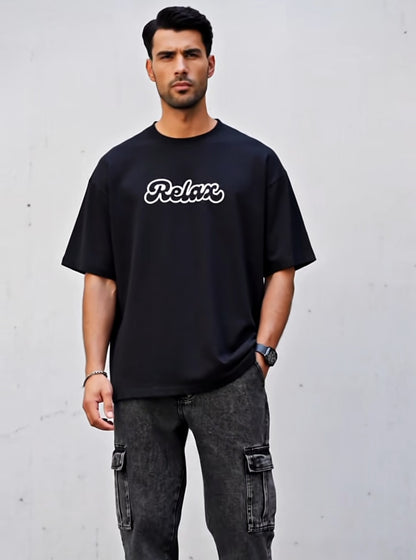 Man wearing a black t-shirt with 'Relax' text against a gray background