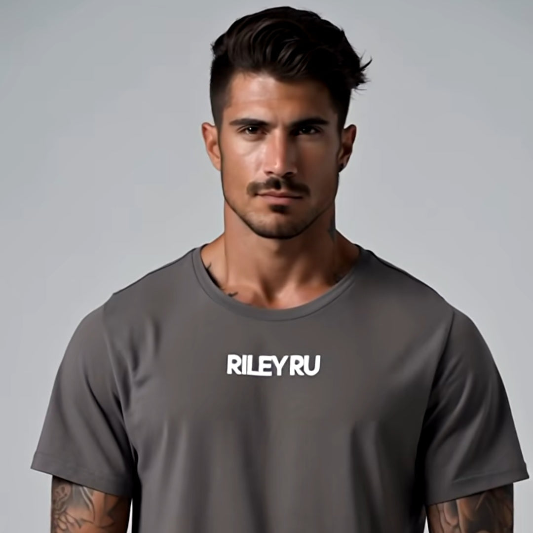 Man wearing a gray t-shirt with 'RILEYRU' logo on a gray background