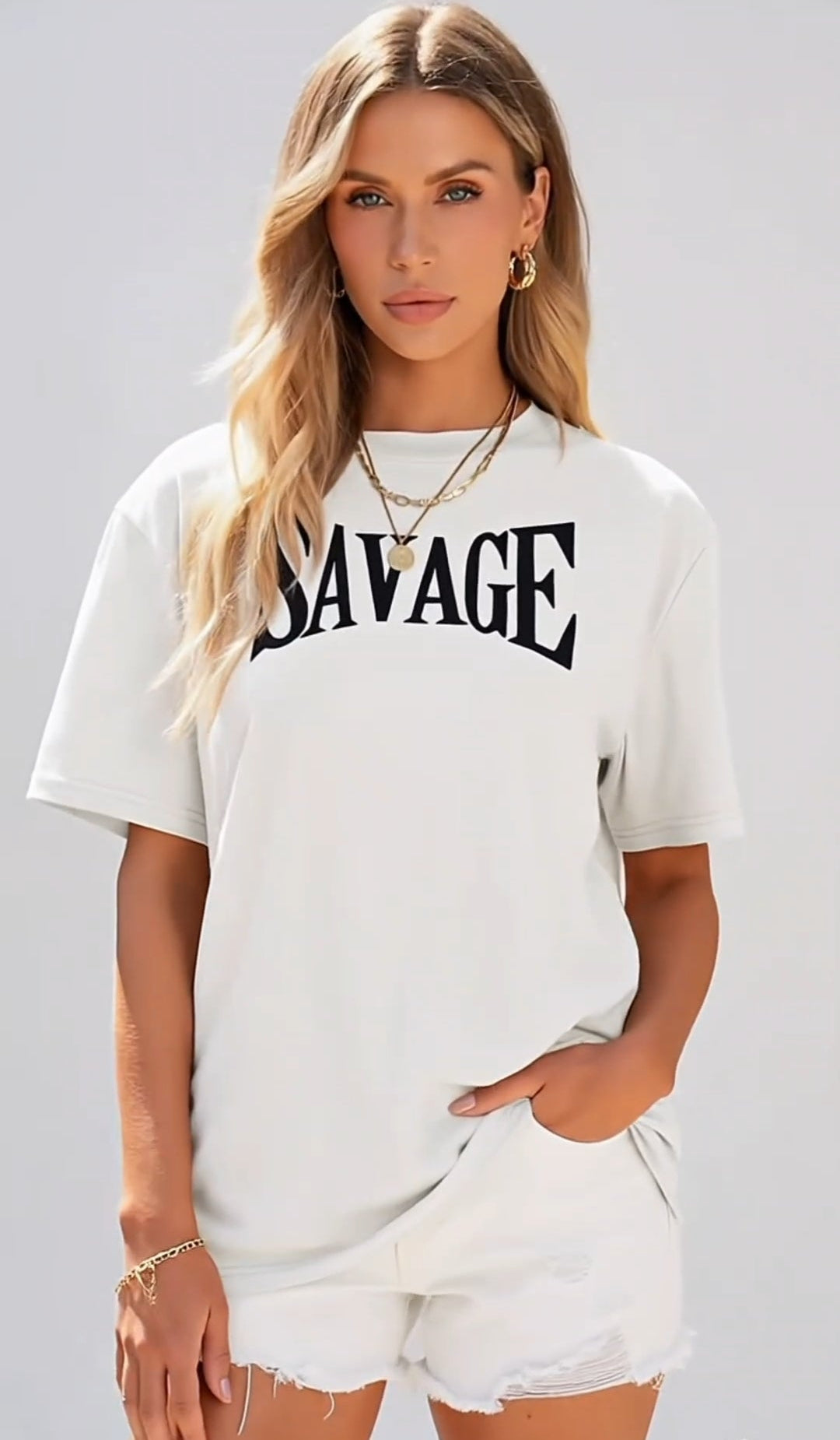 Woman wearing a white t-shirt with 'SAVAGE' printed on it against a plain background