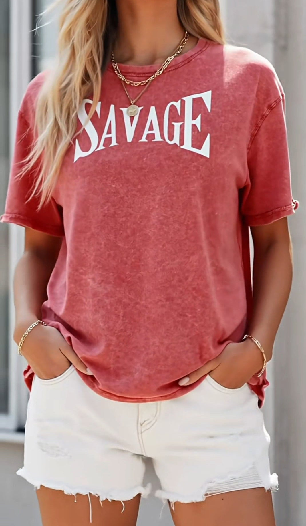 Person wearing a red 'SAVAGE' t-shirt and white shorts.