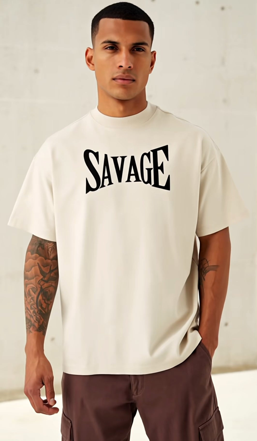 Man wearing a white t-shirt with 'SAVAGE' printed on it against a plain background