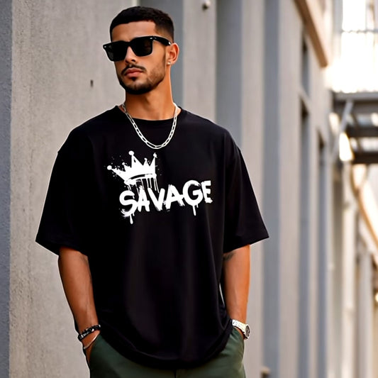 Man wearing a black 'Savage' t-shirt, green cargo pants, and white sneakers on a street.