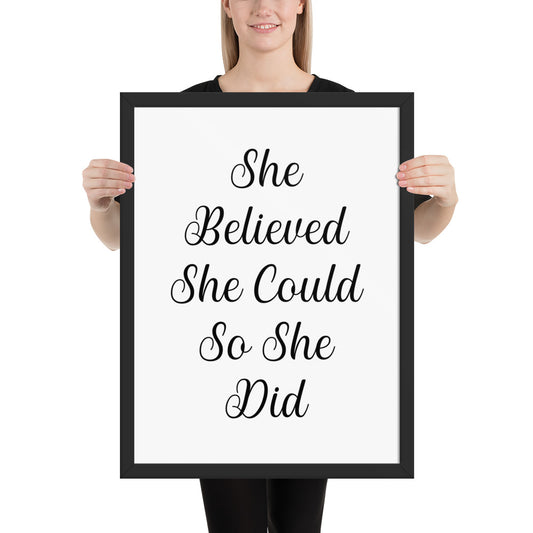 Person holding a framed print with 'She Believed She Could So She Did' text.
