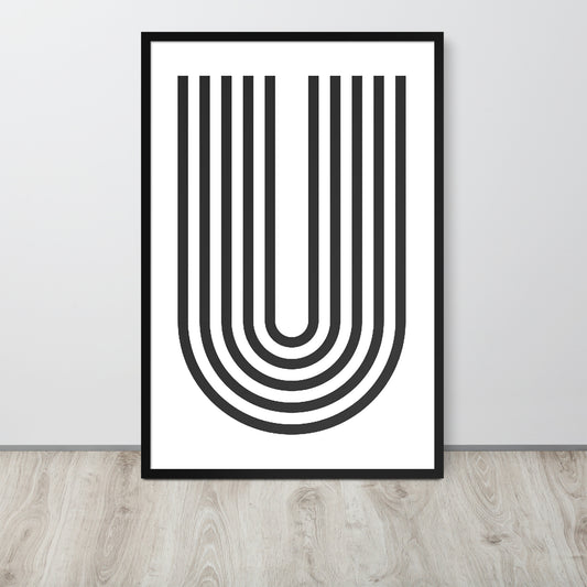 Framed abstract art print with black U-shaped lines on a white background, placed on a wooden floor.