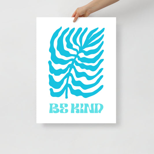 Poster with blue leaf design and 'Be Kind' text held by a hand on a light gray background