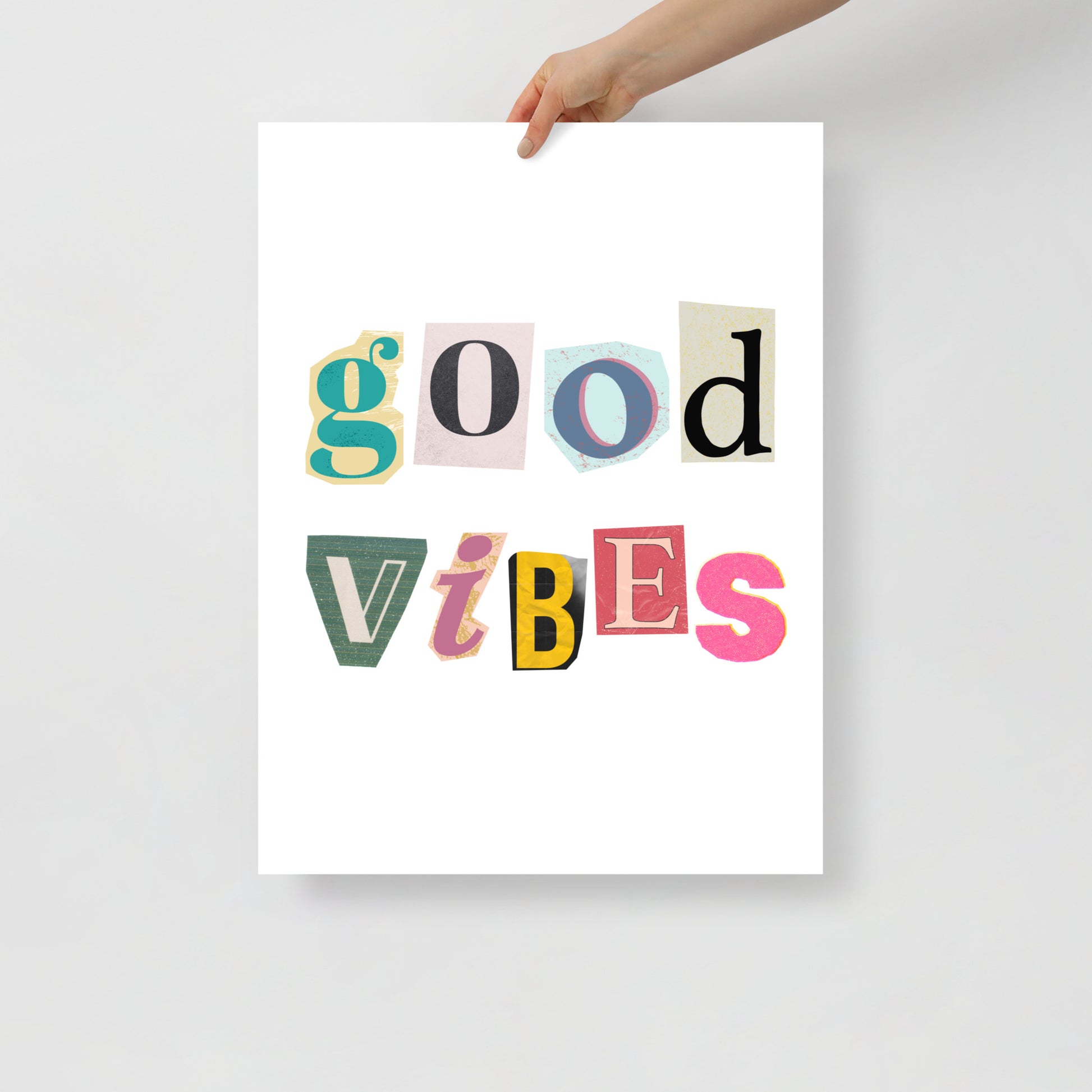 Poster with 'good vibes' text in colorful letters held by a hand on a light gray background