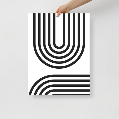 Poster with black and white geometric design held by a hand on a light gray background