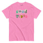 Pink t-shirt with 'good vibes' text in colorful letters on a white background