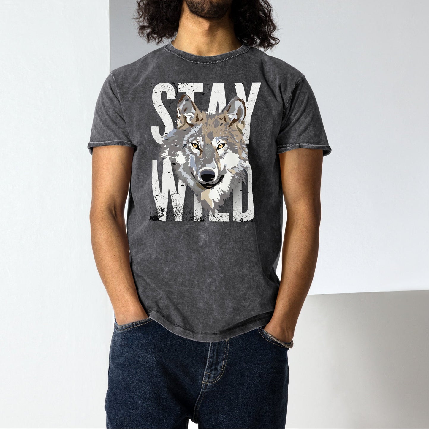 Man wearing a dark gray t-shirt with a wolf graphic and 'Stay Wild' text against a plain background
