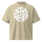 Beige t-shirt with 'Stay Weird' text in white on a white background