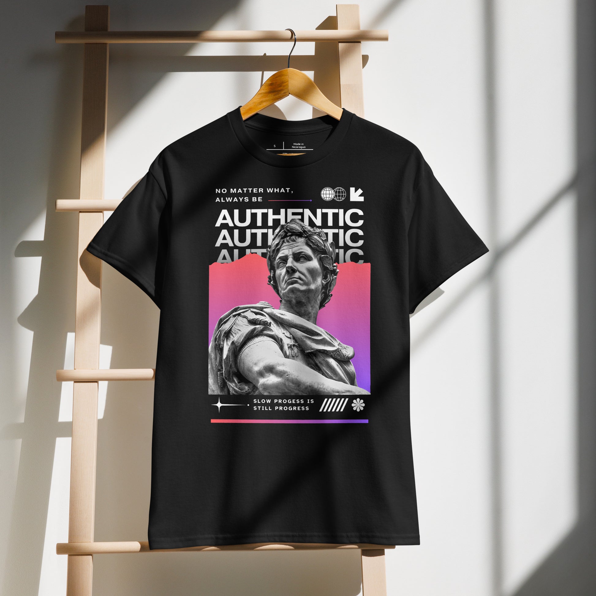 Black t-shirt with graphic design of a statue and text on a wooden rack.