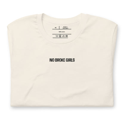 Folded cream t-shirt with 'NO BROKE GIRLS' text on a white background